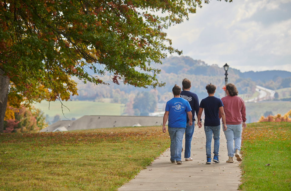 A picture of students walking down a sidewalk.